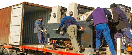 Machinery movers loading a 20 ton machine on the vehicle.